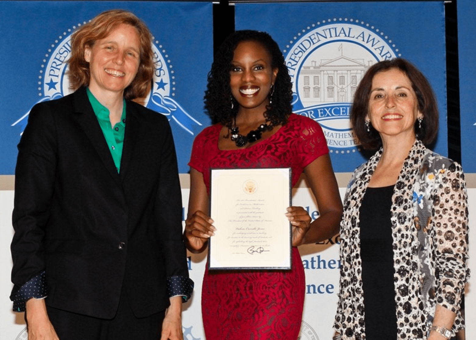 Dr. Valerie Camille Jones holding her Presidential Award for Excellence in Mathematics and Science Teaching certificate between Megan Smith, U.S. Chief Technology Officer and Director of the National Science Foundation, Dr. France A. Còrdova.
